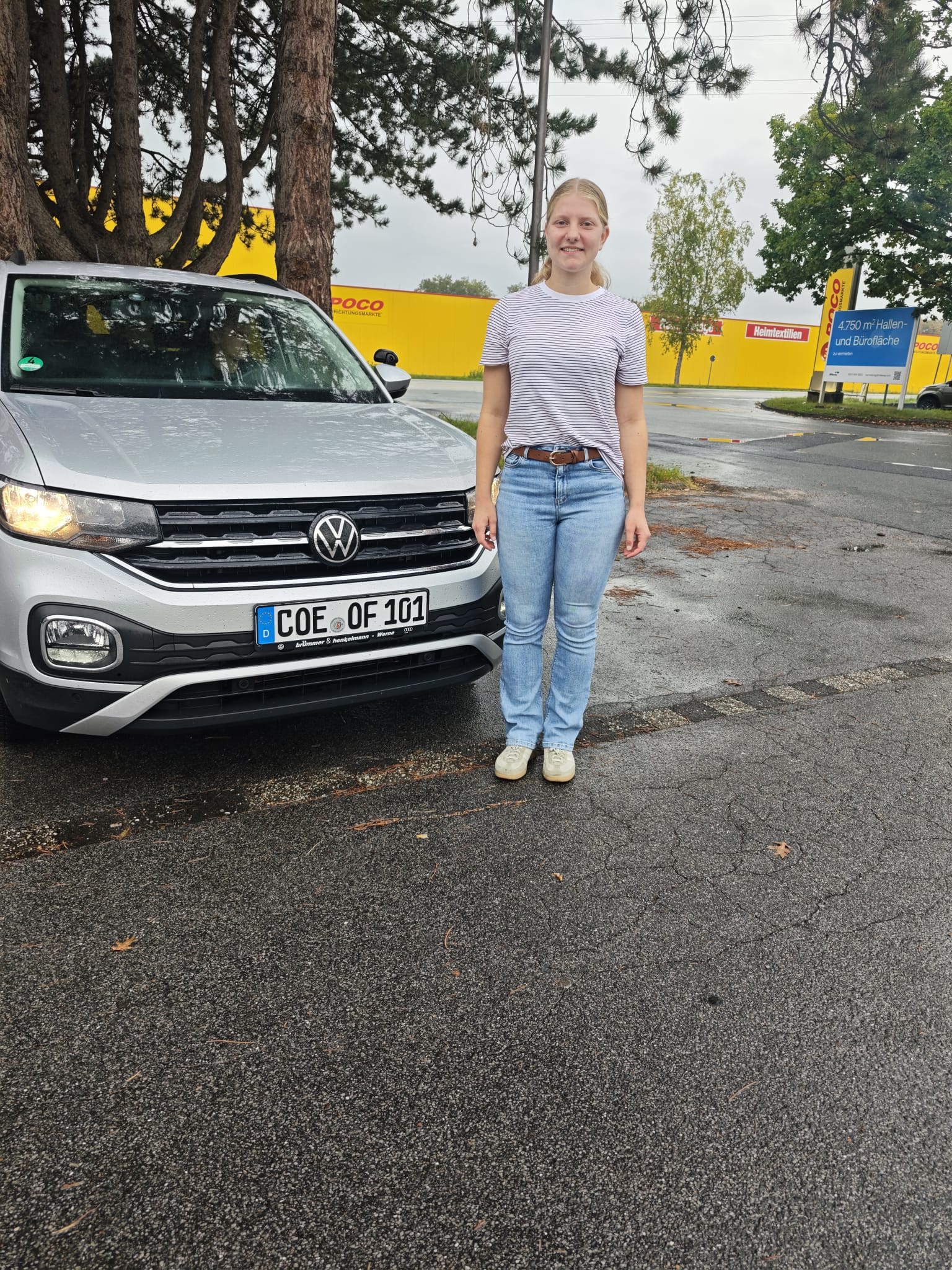 Friederike neben dem VW T-Cross der Fahrschule nach bestandener Prüfung